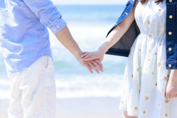 浜辺で手をつなぐカップル